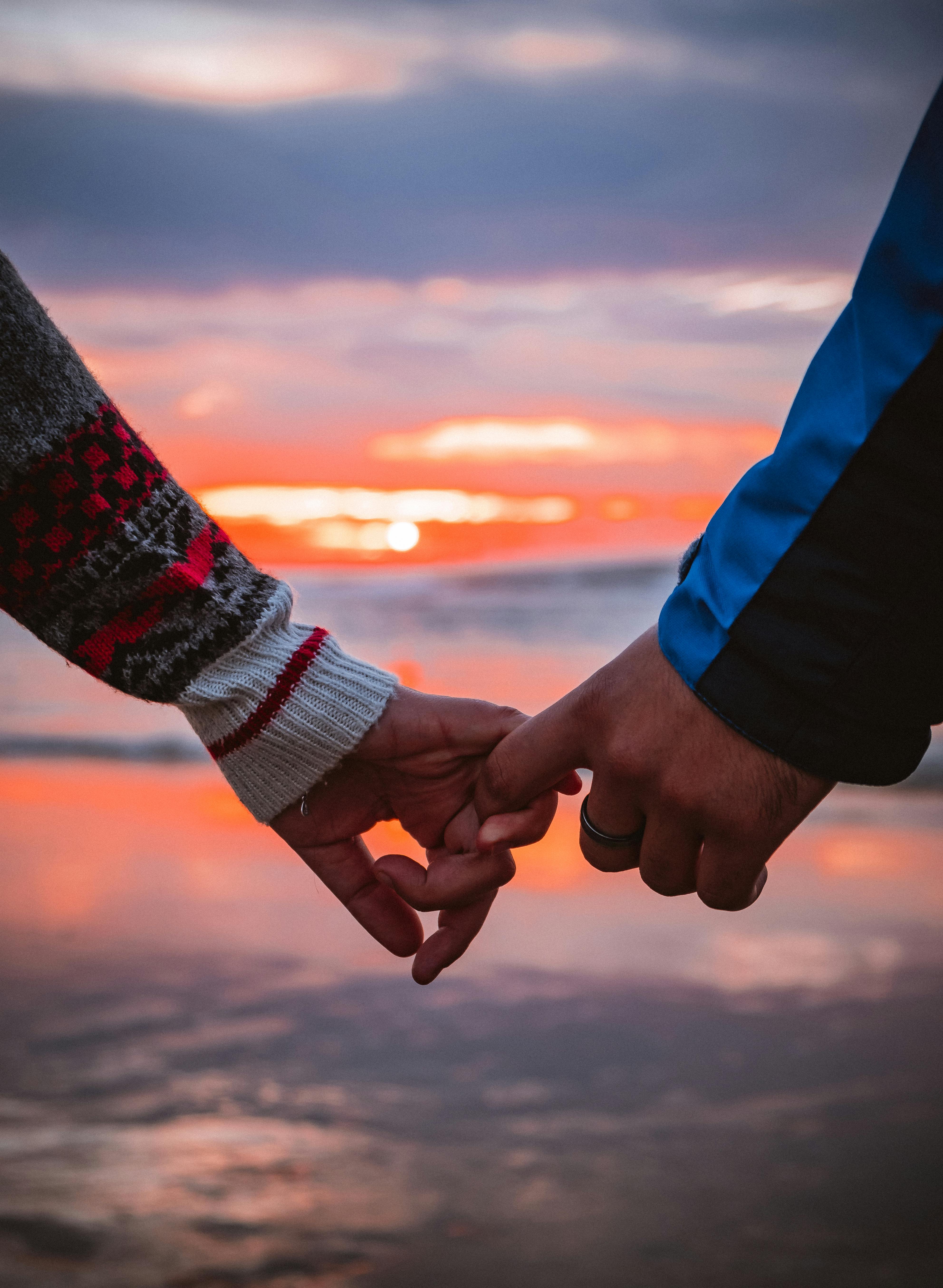 Couple holding hands at sunset